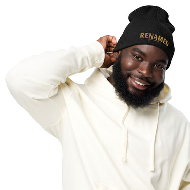 Male model wearing Renamed Organic Ribbed Beanie in Black, front view with Old Gold embroidery